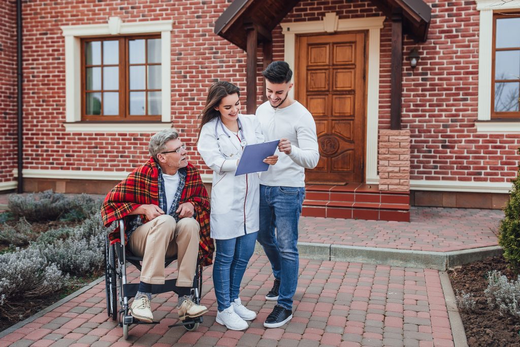 son-with-nurse-speaking-about-old-man-whelchair-looking-his-results