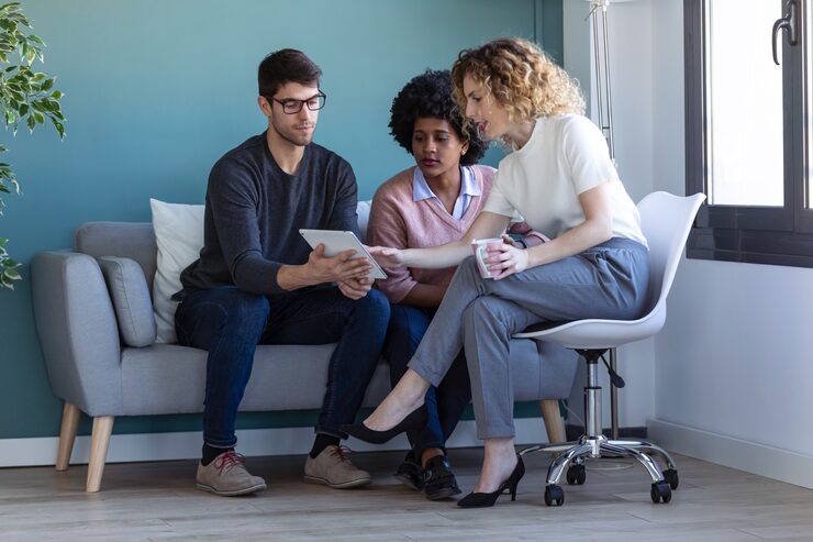 shot-casual-young-business-people-working-with-digital-tablet-while-are-sitting